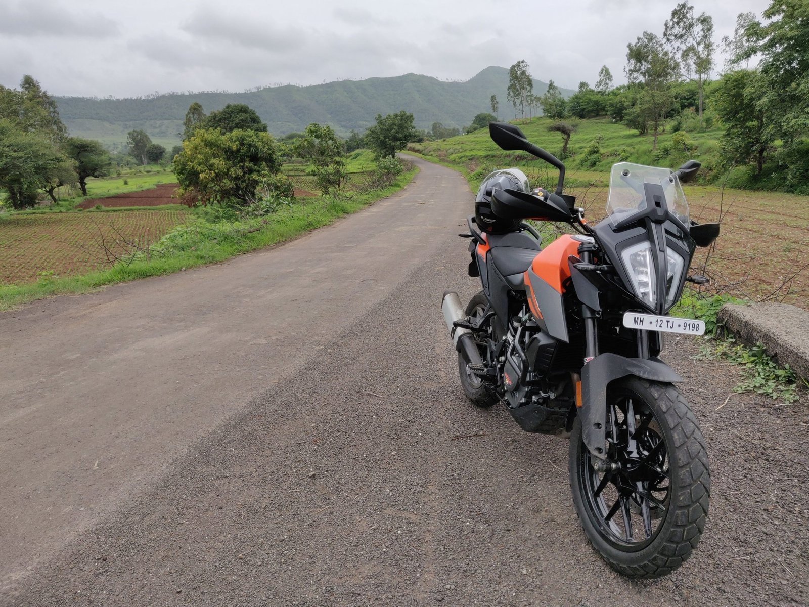 KTM 390 Adventure parked beside a countryside road.